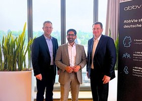 Der Wirtschaftsminister Hessens und zwei weitere Personen stehen vor einem Fenster nebeneinander und schauen in die Kamera.