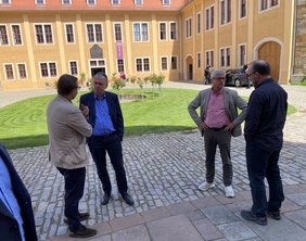 Vertreter der Bauwirtschaft, Verwaltung und Politik im Gespräch im Innenhof des Schlosses Ettersburg