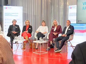 Teilnehmer der Gesprächsrunde sitzen für ein Dialog zusammen